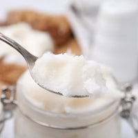 Spoonful of pastured pork lard taken from a glass jar, perfect for cooking and baking.